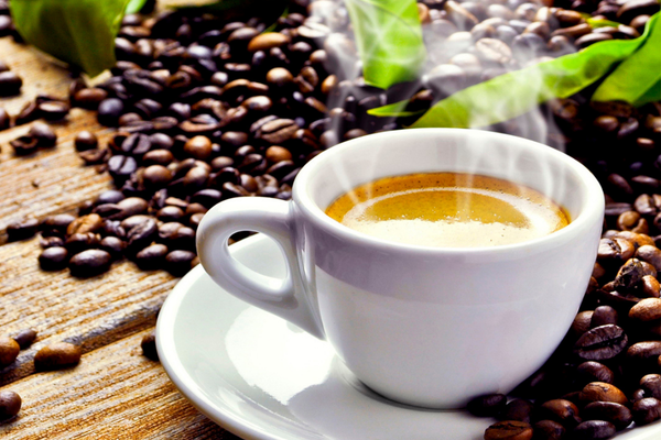 cup of steaming coffee surrounded by coffee beans