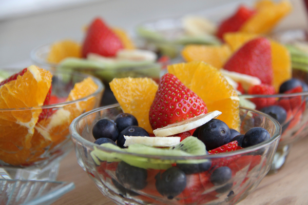 clear bowl with a variety of cut fruit