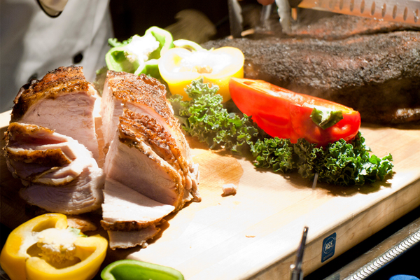 sliced turkey on cutting board at a carving station