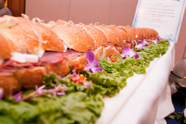 long sub sandwich on a table surrounded by lettuce