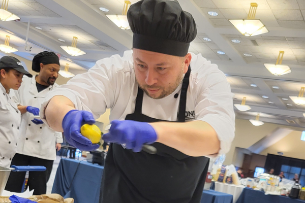chef squeezing lemon on dish