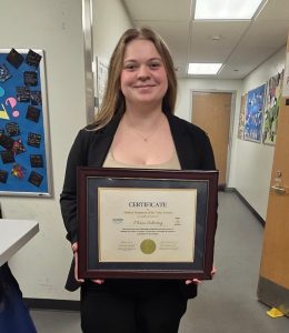 Maia Schwing posing with award certificate for Student Employee of the Year